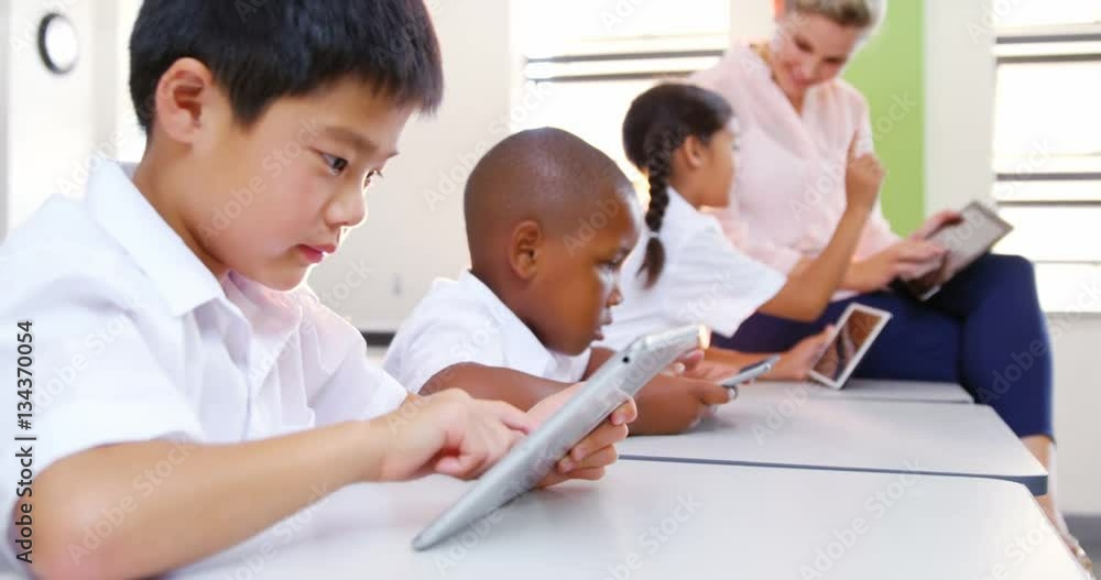 School kids and teacher using digital tablet in classroom at school 4k School kids and teacher using digital tablet in classroom at school 4k
