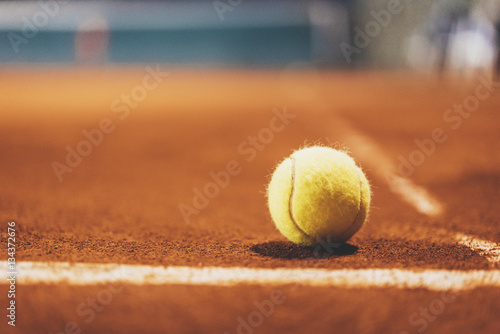 Yellow tennis bal on empty court, blurred background with area for your text message or content