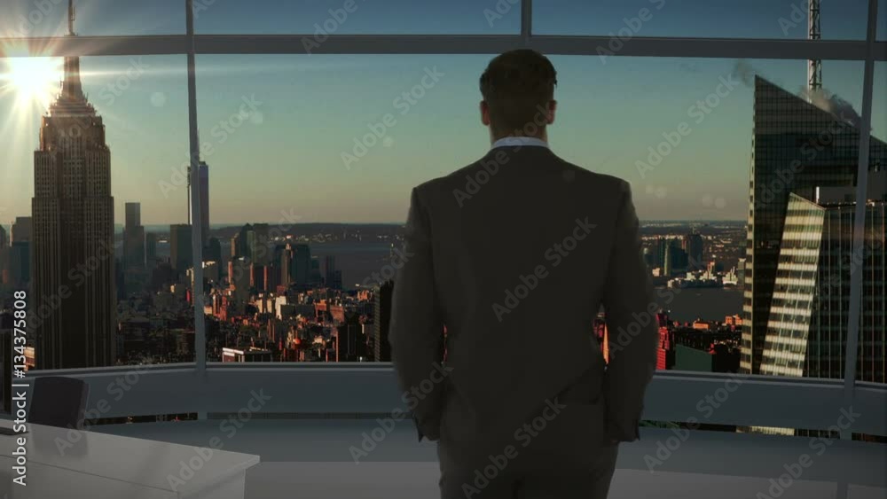 Businessman standing and looking at office window Businessman standing and looking at office window