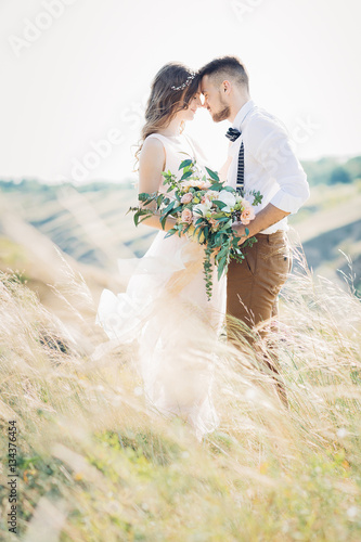bride and groom hugging at the wedding in nature. Fototapeta