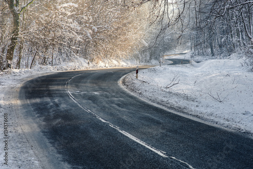 Frosty, slippery road in the deep forest at winter