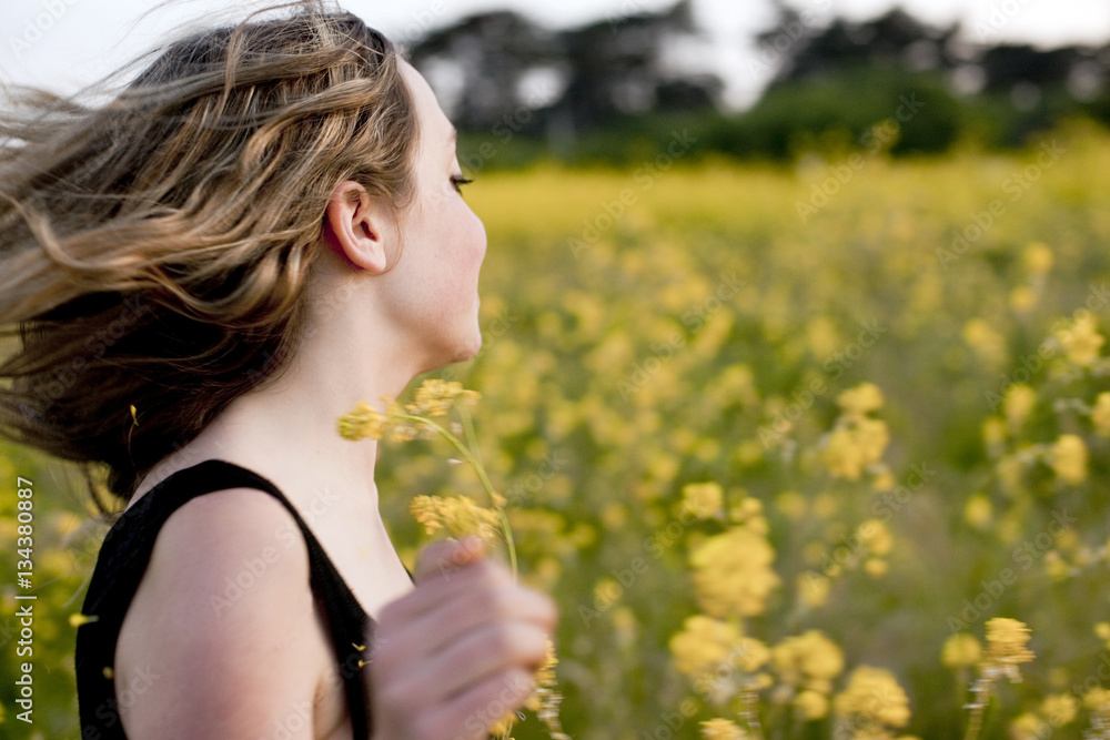 Teenage girl with flowers frolicking in meadow Teenage girl with flowers frolicking in meadow