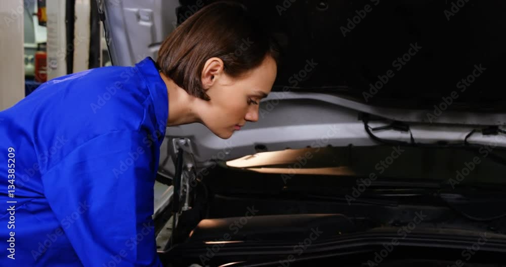 Female mechanic checking a automobile car at repair shop 4k Female mechanic checking a automobile car at repair shop 4k