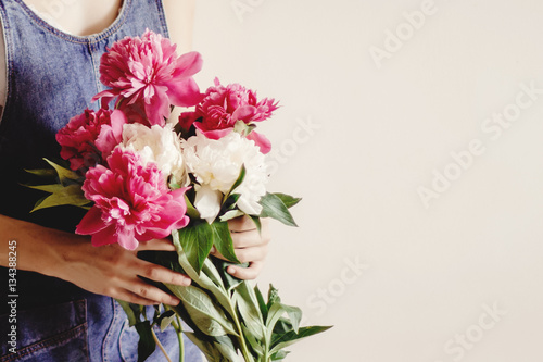 Fototapeta Naklejka Na Ścianę i Meble -  woman hipster in denim dress holding peony bouquet in the mornin