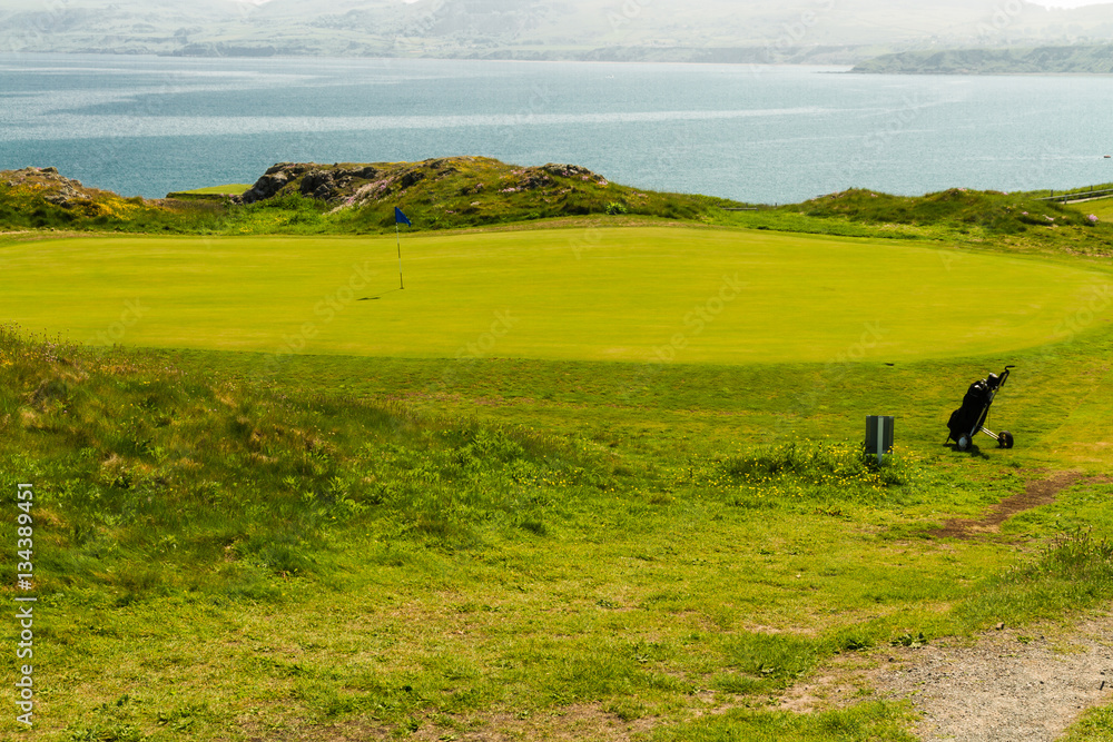 Golf course putting green sea in background and golf bag. Golf course putting green sea in background and golf bag.