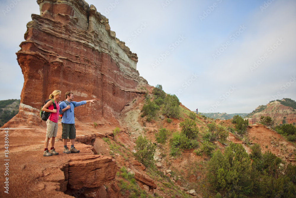 Happy young couple take a break from hiking to admire the view. Happy young couple take a break from hiking to admire the view.