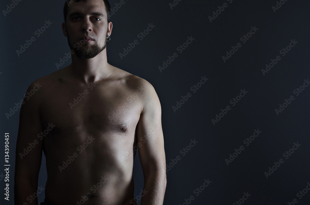 Fototapeta premium Athletic man with a bare-chested on a black background.