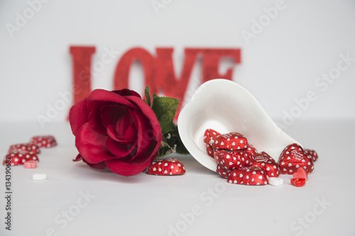 Fototapeta Naklejka Na Ścianę i Meble -  Red rose with heat shaped candies and love sign