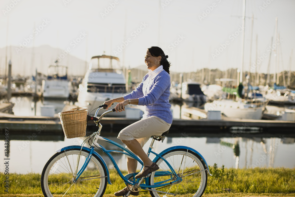 Mature woman riding her bike at the waterfront Mature woman riding her bike at the waterfront
