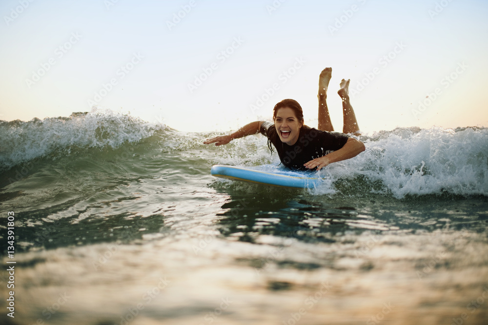 Smiling young woman surfboarding in sea Smiling young woman surfboarding in sea