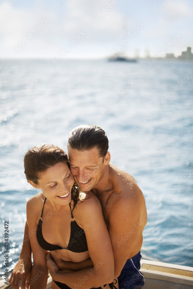 Happy mid adult couple embracing on the deck of a boat Happy mid adult couple embracing on the deck of a boat