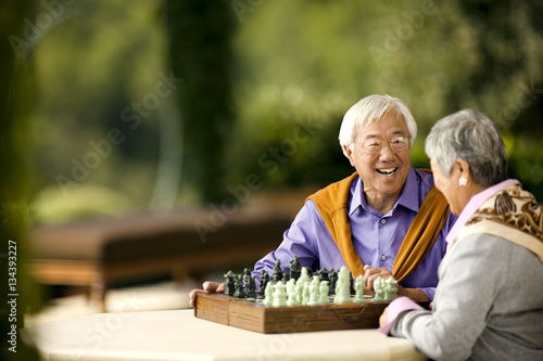 Happy senior couple playing a game of chess.
