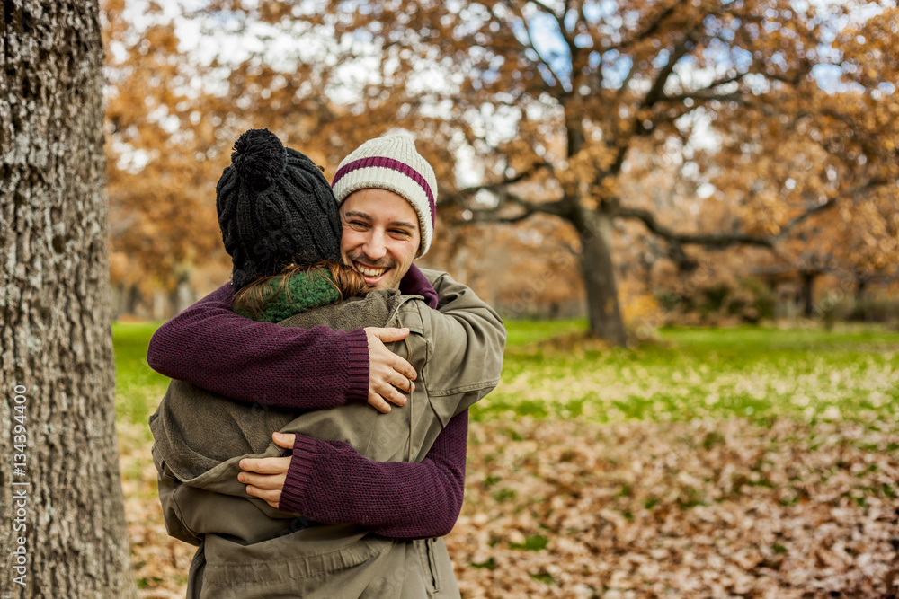 Portrait young couple hugging in an autumn background. Back view Portrait young couple hugging in an autumn background. Back view