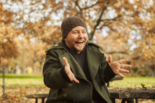 Portrait man laughing with wool hat in autumn background