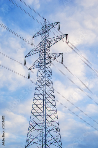 Strommast mit Leitungen vor morgendlichem Himmel