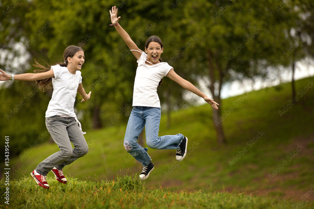 Two girls excitedly jumping in air. Two girls excitedly jumping in air.