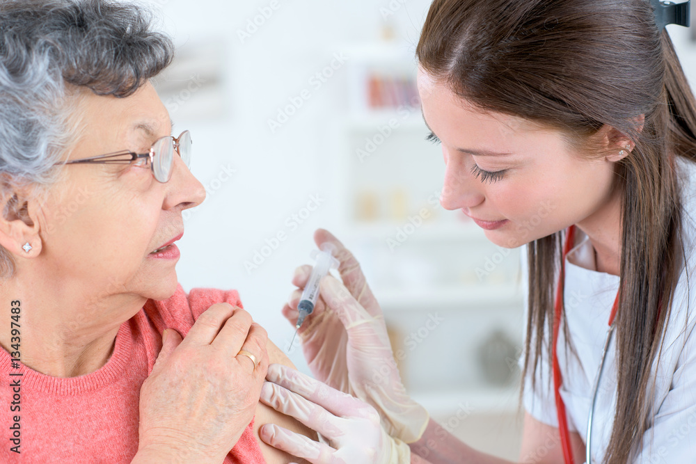 beautiful and experienced female doctor injecting medicine to alzheimer patient beautiful and experienced female doctor injecting medicine to alzheimer patient
