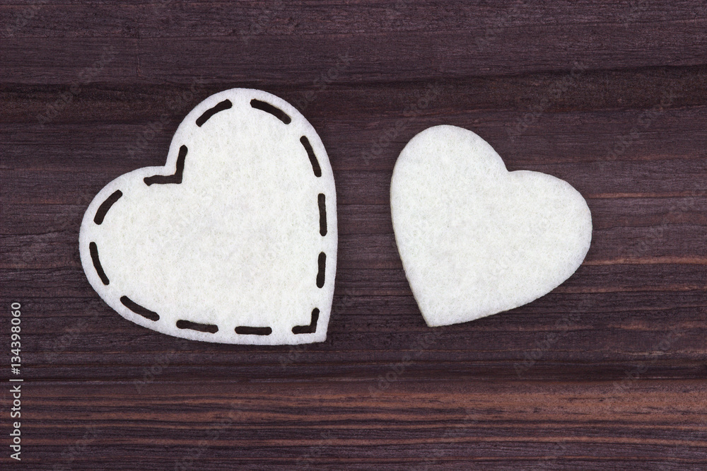 Two white hearts of felt on a brown wooden background. Valentine Day. Greeting Card. Two white hearts of felt on a brown wooden background. Valentine Day. Greeting Card.