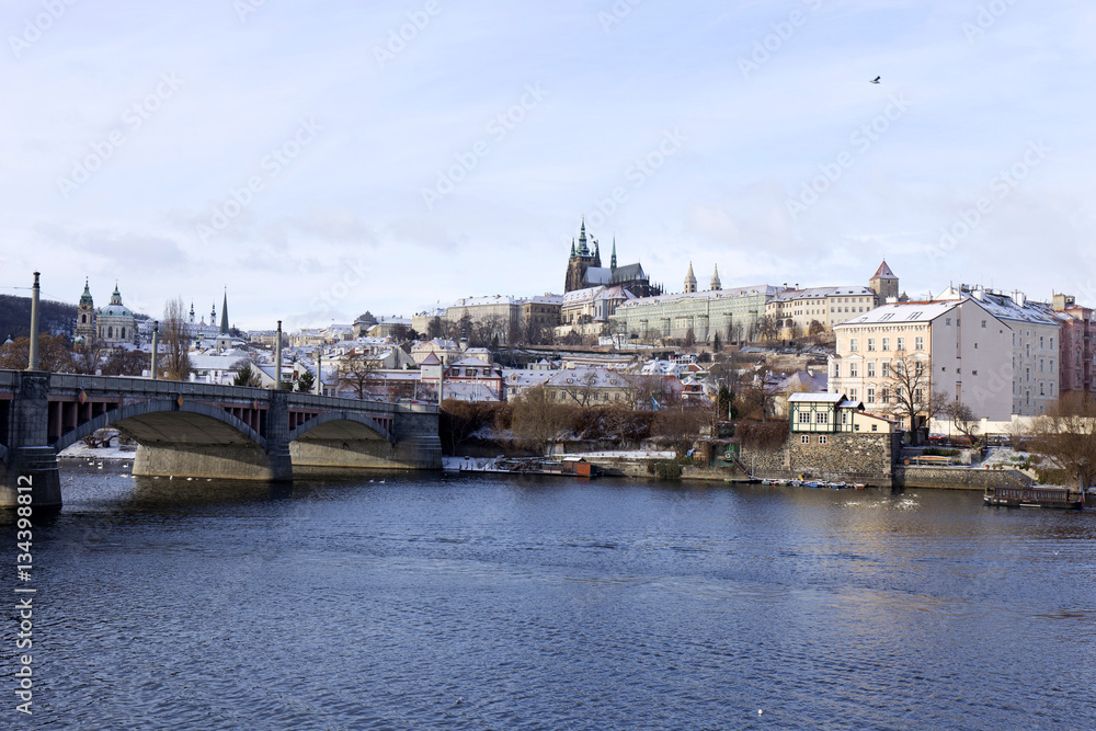 Fototapeta premium Snowy freeze Prague Lesser Town with gothic Castle above River Vltava, Czech republic
