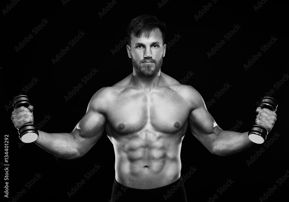 Young man training with dumbbells. Black and white photo