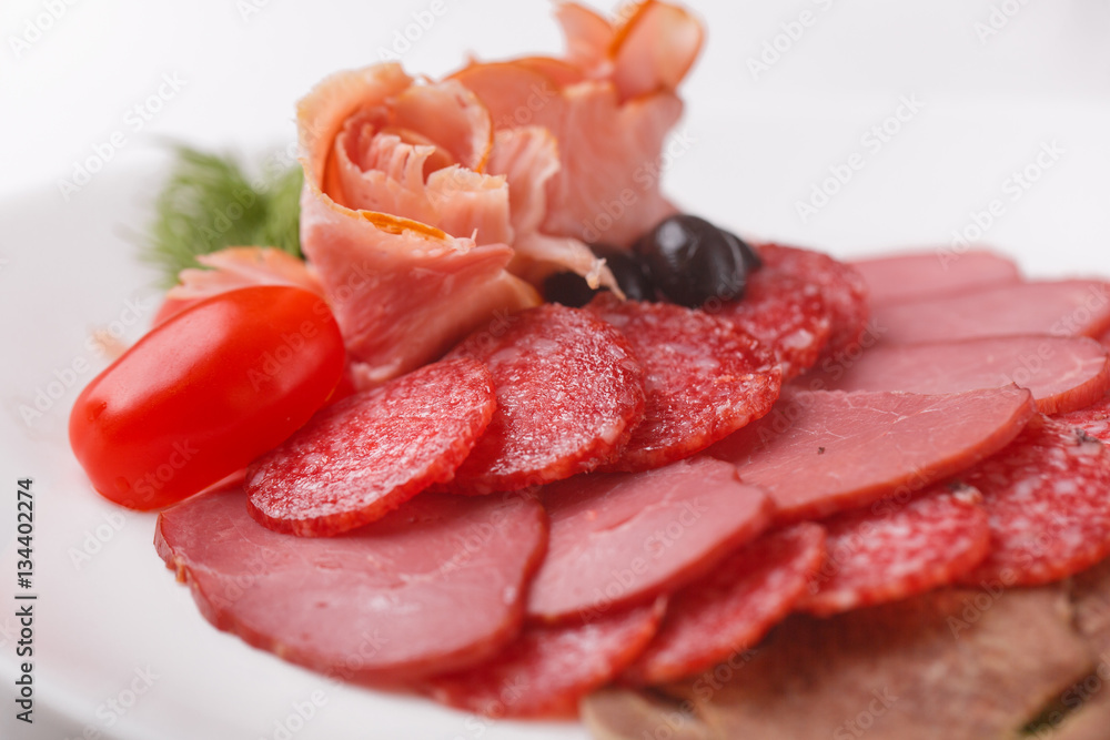 thin slices of sausage and meat on a plate   white background