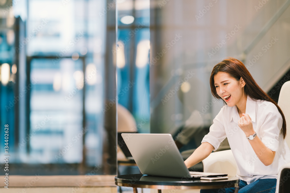 Beautiful Asian girl celebrate with laptop, success happy pose. E-commerce, university education, internet technology, or startup small business concept. Modern office or living room with copy space Beautiful Asian girl celebrate with laptop, success happy pose. E-commerce, university education, internet technology, or startup small business concept. Modern office or living room with copy space