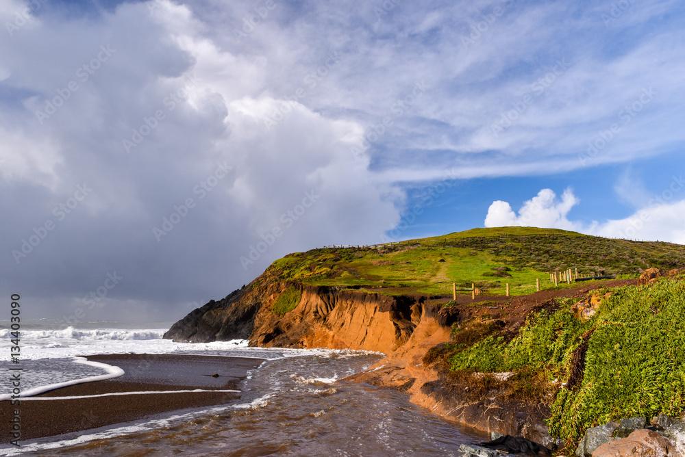 Obraz premium Stormy weather by a cliff at beach