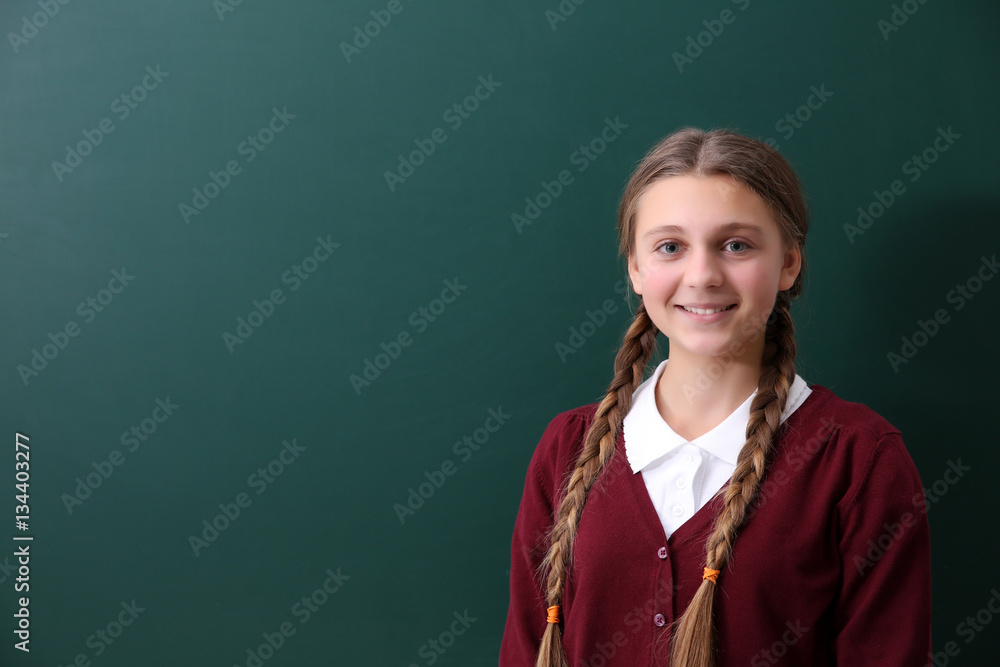 Teenage girl standing near green school blackboard Teenage girl standing near green school blackboard