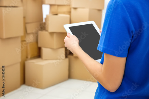 Young woman holding tablet at warehouse, closeup