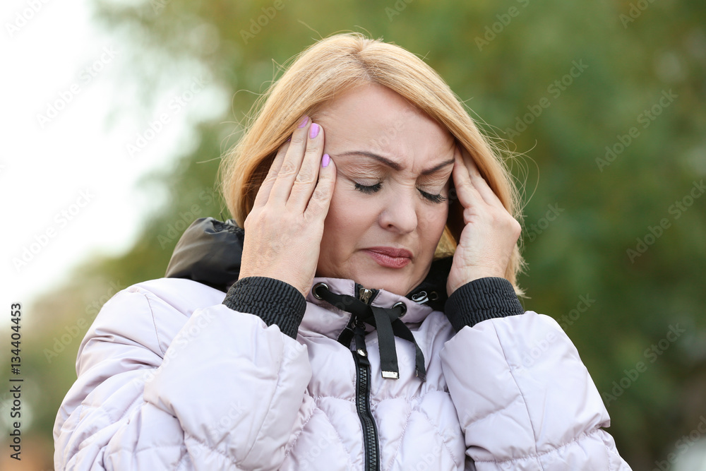 Senior woman suffering from headache outdoors Senior woman suffering from headache outdoors