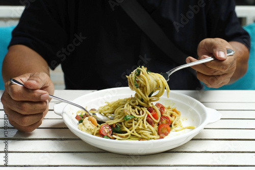 man hands holding fork and spoon during eating spaghetti