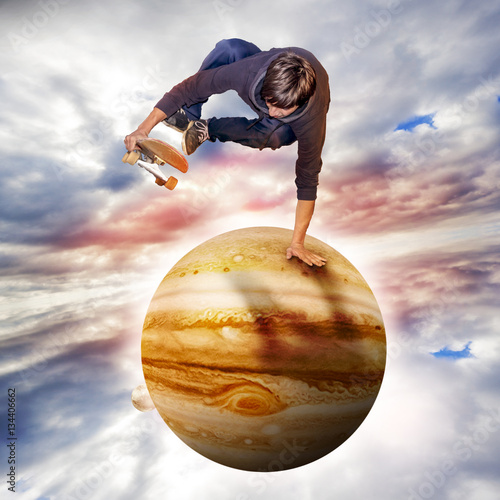 young skateboarder jumping over the jupiter planet aerial view