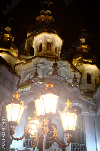 Church of the Holy Myrrh-Bearers of the Mirror stream. Kharkiv. Ukraine. Detailed photo of Church with golden domes and relief decors at night photo