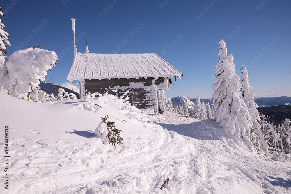 Mountain wooden huts covered with frozen snow. Grosser Arber, Bayerisch Eisenstein, Germany. Winter snowy summit of Mt. Grosser Arber at Bavarian Forest (Germany).