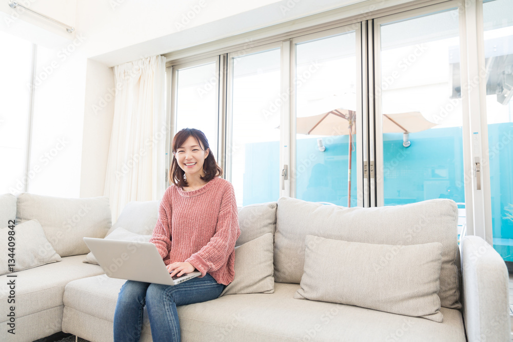 部屋でパソコンを見る女性 部屋でパソコンを見る女性