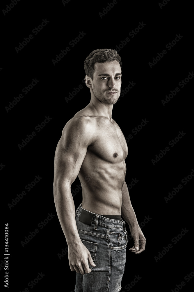 Handsome shirtless muscular man's profile, looking away, isolated on black