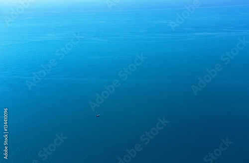 Lonely boat in the vast blue sea