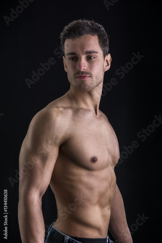 Handsome shirtless muscular man's profile, looking away, isolated on black © theartofphoto
