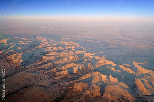Aerial view of Alaskan mountains covered with snow at sunset north of Fairbanks