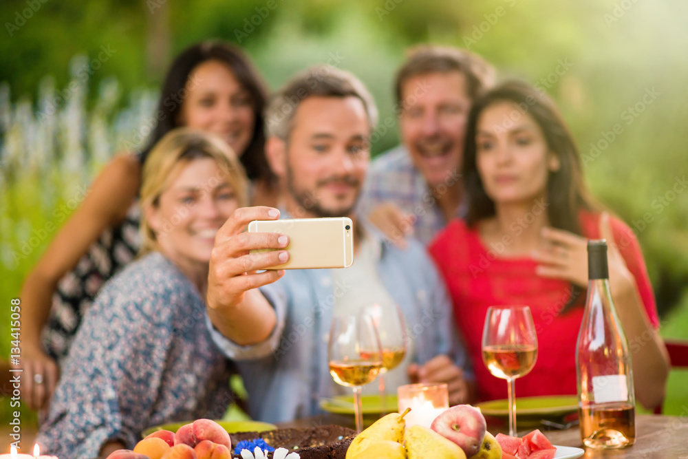 Friends taking a selfie on a terrace by a summer evening Friends taking a selfie on a terrace by a summer evening