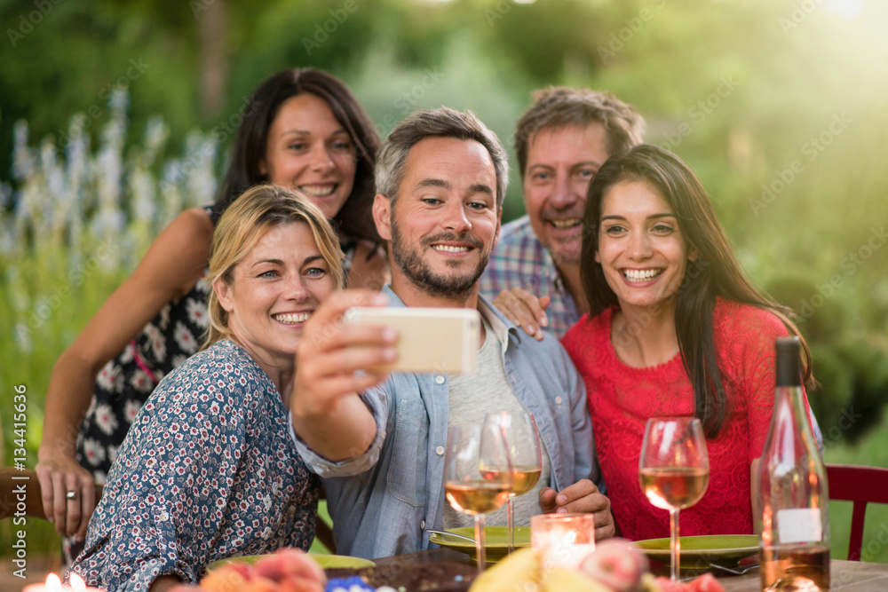 Friends taking a selfie on a terrace by a summer evening Friends taking a selfie on a terrace by a summer evening