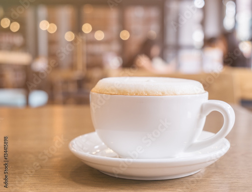 Cup of Cappuccino Coffee with foam froth cover on top. Cafe shop