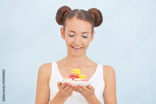 Cute girl with macaroons on...