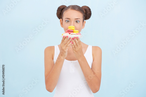 Cute girl with macaroons on...