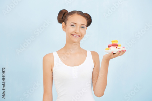 Cute girl with macaroons on...