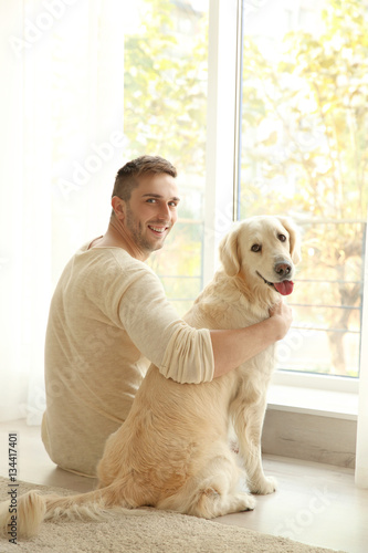 Fototapeta Naklejka Na Ścianę i Meble -  Handsome man with cute dog at home