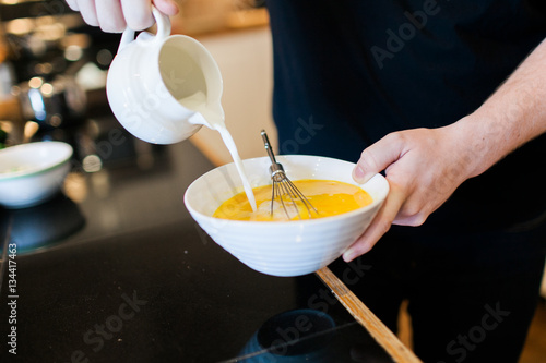 Tableau sur toile Adding milk to scrambled eggs