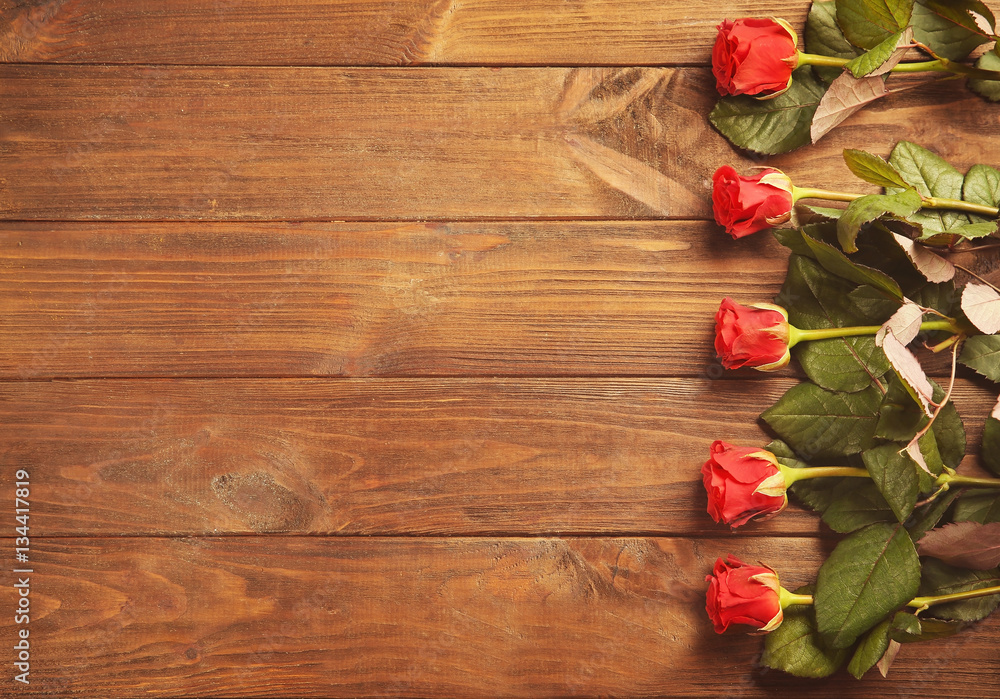 Bouquet of beautiful red roses on wooden background