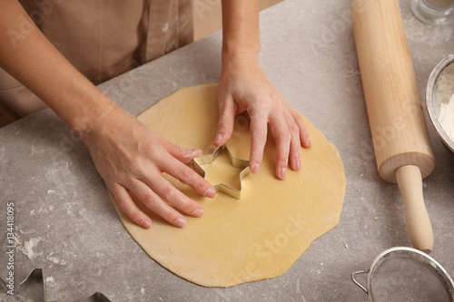 Young woman preparing tasty cookies in kitchen, closeup