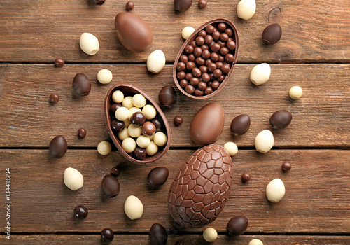 Chocolate Easter eggs and sweets on brown wooden background